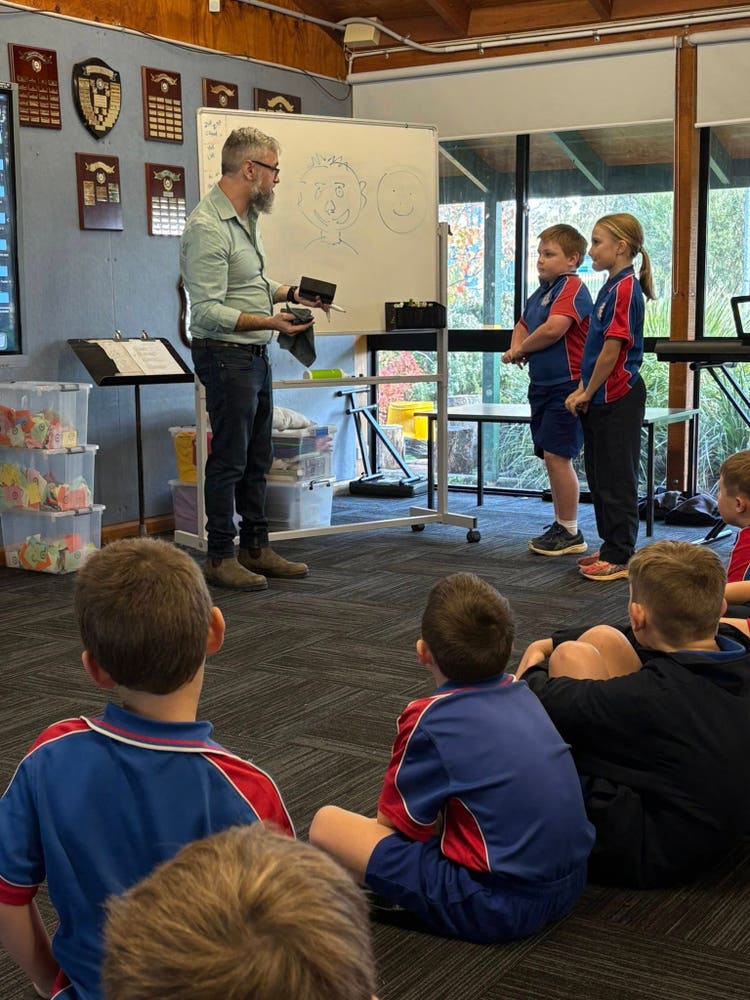 Students and a teacher use technology and digital learning tools, presenting and interacting in a tech-enabled environment.
